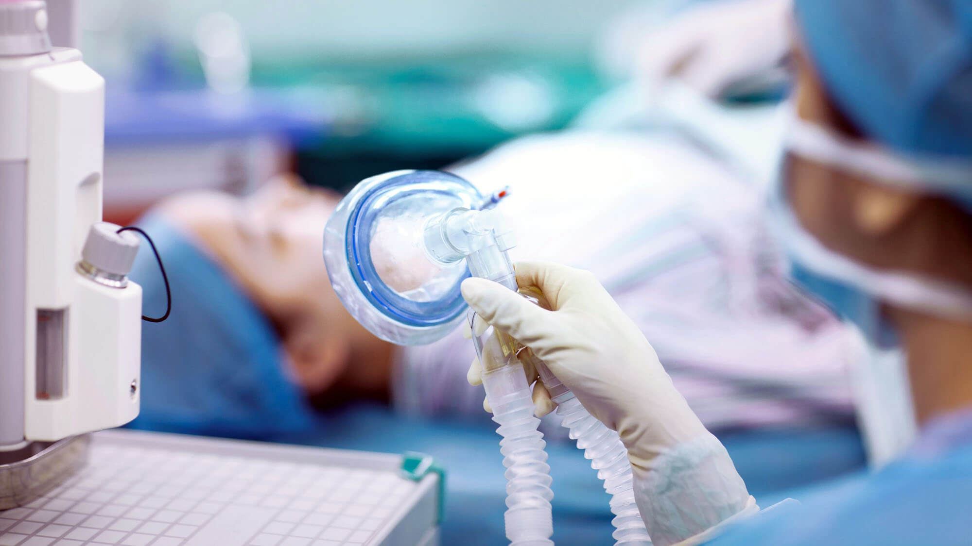 Nurse holding anesthesia mask in operating room
